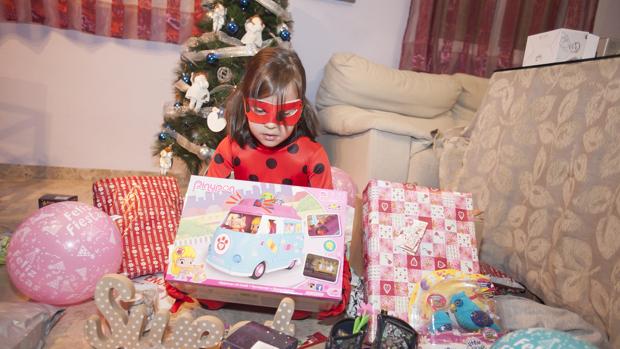 Una niña abre los regalos que le han dejado los Reyes en su salón