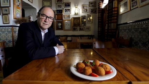 El dueño de esta singular taberna y restaurante posa con su plato estrella