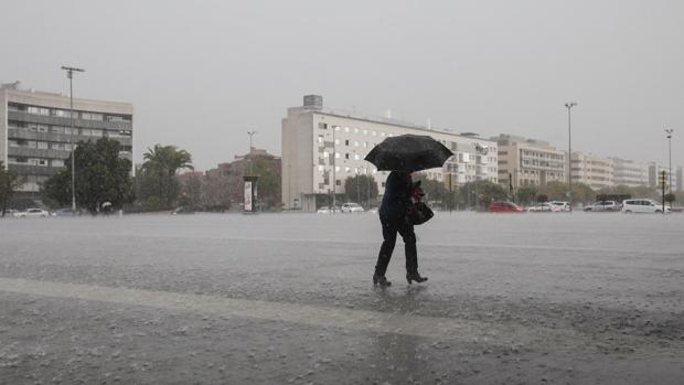 Una mujer se resguardada bajo su paraguas de la lluvia que cae en el centro de Córdoba
