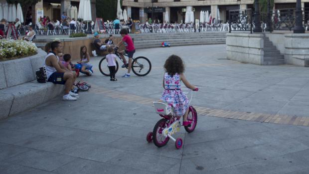 Niños en bicicleta en una plaza