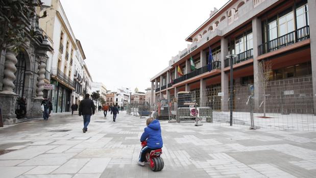 Un niño pasea con su moto en la calle Capitulares