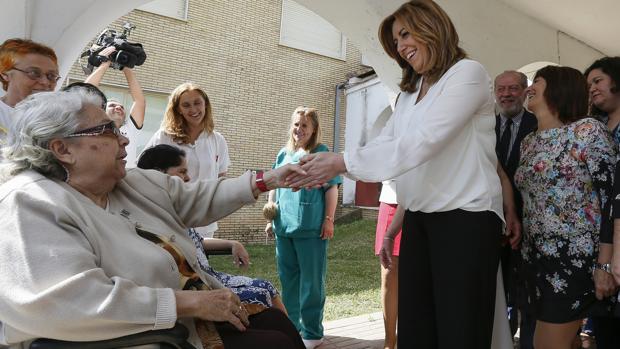 Susana Díaz saluda a una mujer durante su visita hoy a las instalaciones de la Fundación Indace