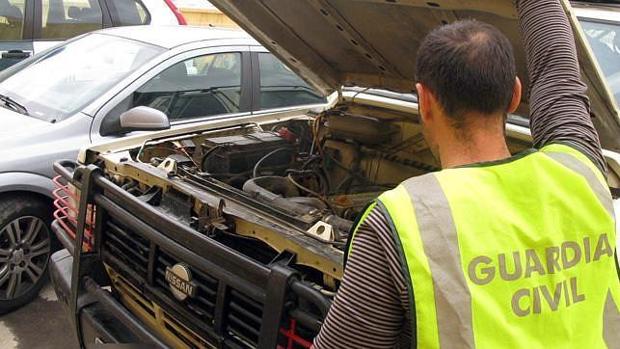 Un agente de la Guardia Civil revisa el motor de un coche