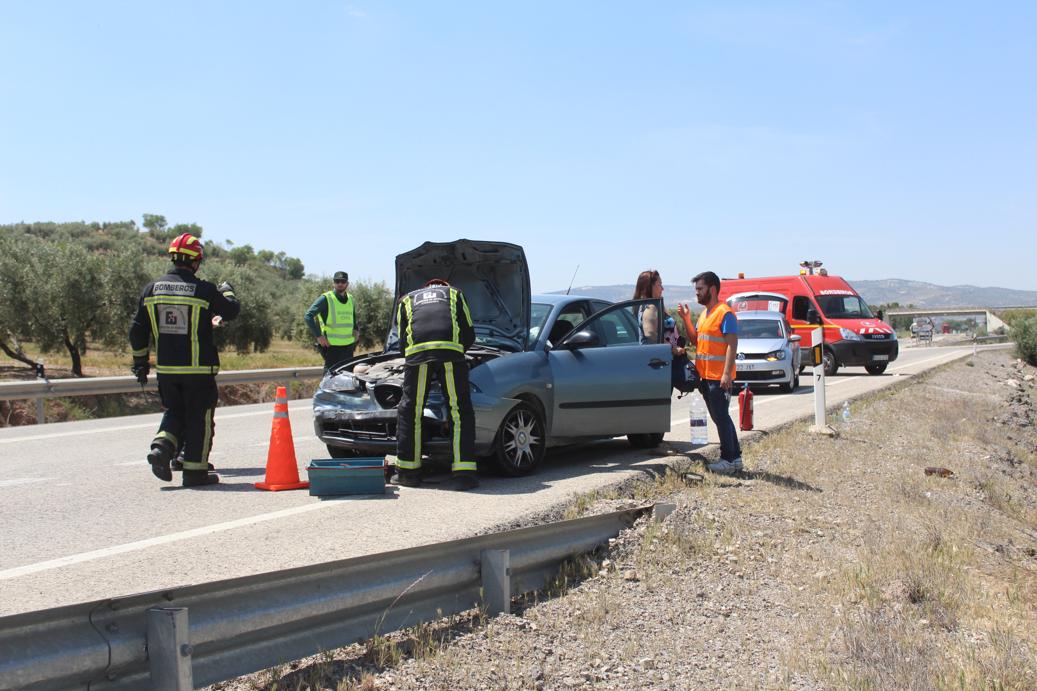 Bomberos y Guardia Civi en el lugar de los hechos con uno de los vehículos implicados