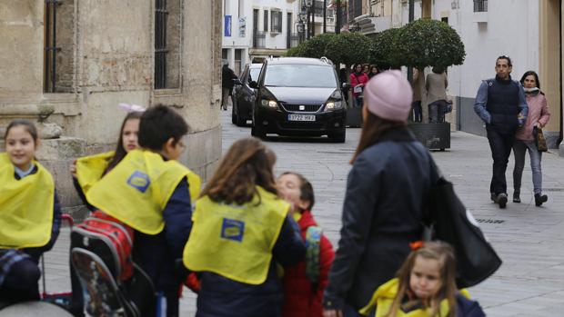 Varios vehículos circulan junto a una zona cercana a un colegio