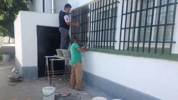 Operarios arreglando la ventana por la que entraron los asaltantes