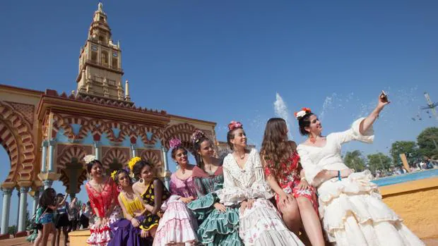 Un grupo de jóvenes vestidas de flamenca se hace un autorretrato junto a la portada