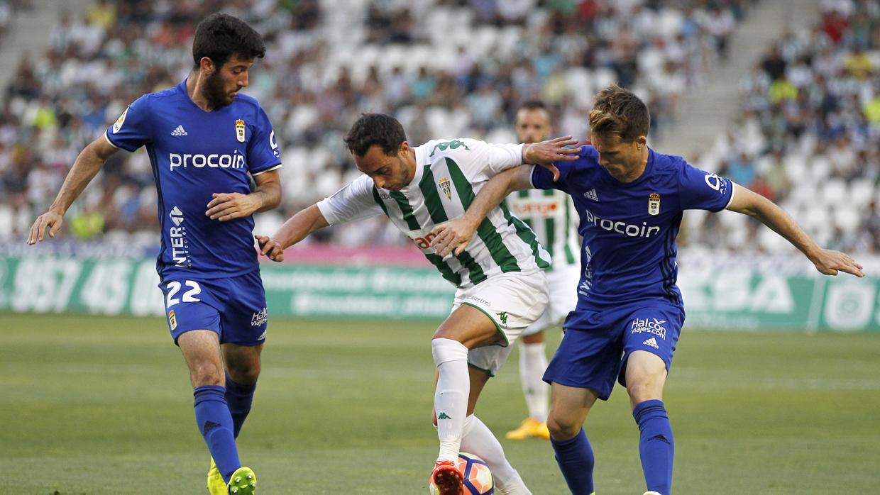 Sergio Aguza lucha con los jugadores del Real Oviedo Nando y Susaeta