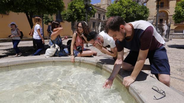 Varios turistas se refrescan en una fuente de Córdoba