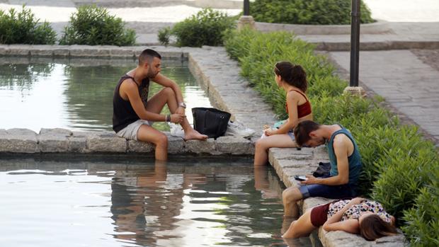 Jóvenes refrescándose en una de las fuentes públicas de Córdoba