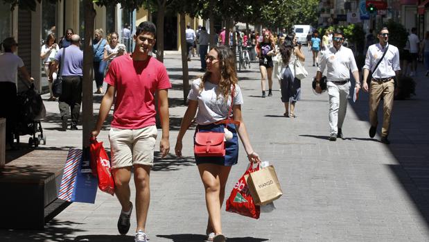 Una pareja pasea por Cruz Conde con bolsas de las rebajas