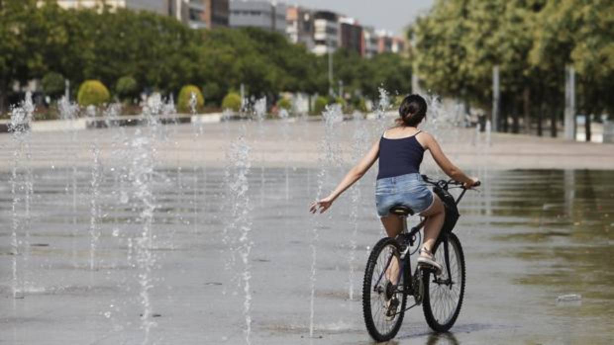 Una mujer se refresca en las fuentes del Vial Norte, ayer en la primera jornada de la ola de calor