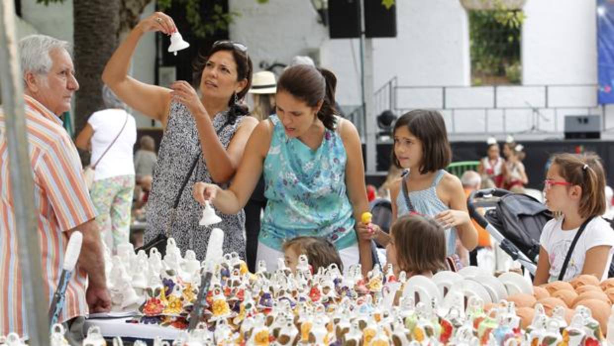 Un grupo de personas ante uno de los populares puestos de campanitas de la Velá