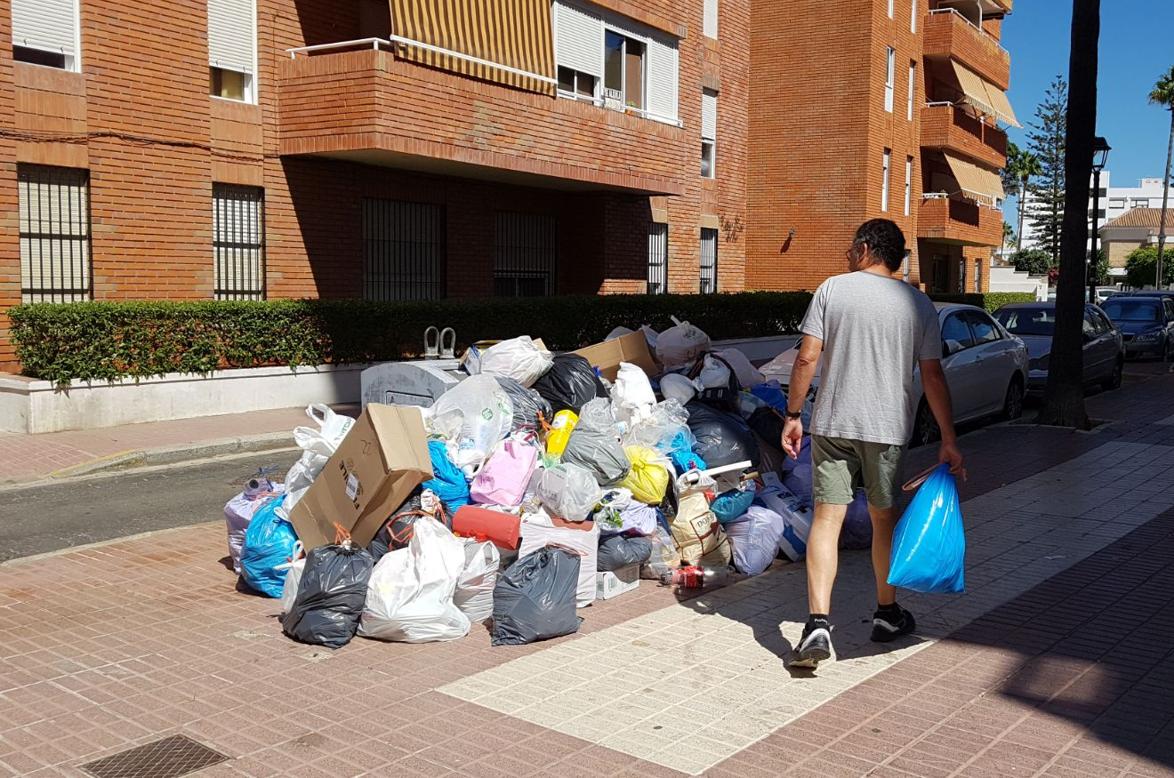 Un vecino se dispone a tirar la basura, ayer en Rota