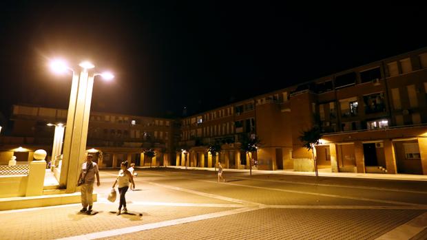 Dos personas pasan por la Plaza Patio La Voz del Pueblo de Las Moreras donde se produjo el apuñalamiento