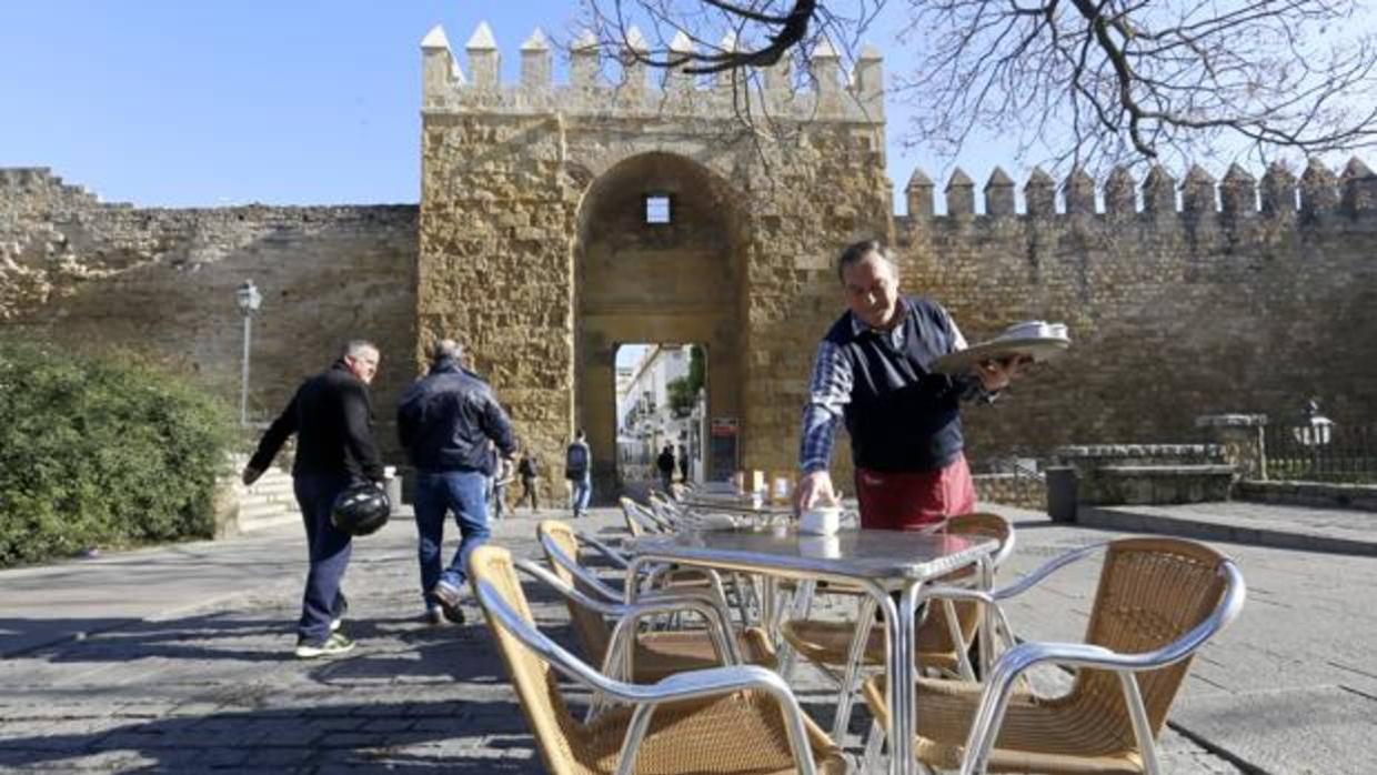 El propietario de la taberna El Malacara recoge una de las mesas junto a la muralla