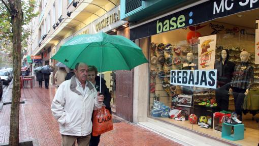 Una pareja tras hacer compras en Santa Rosa en un día lluvioso