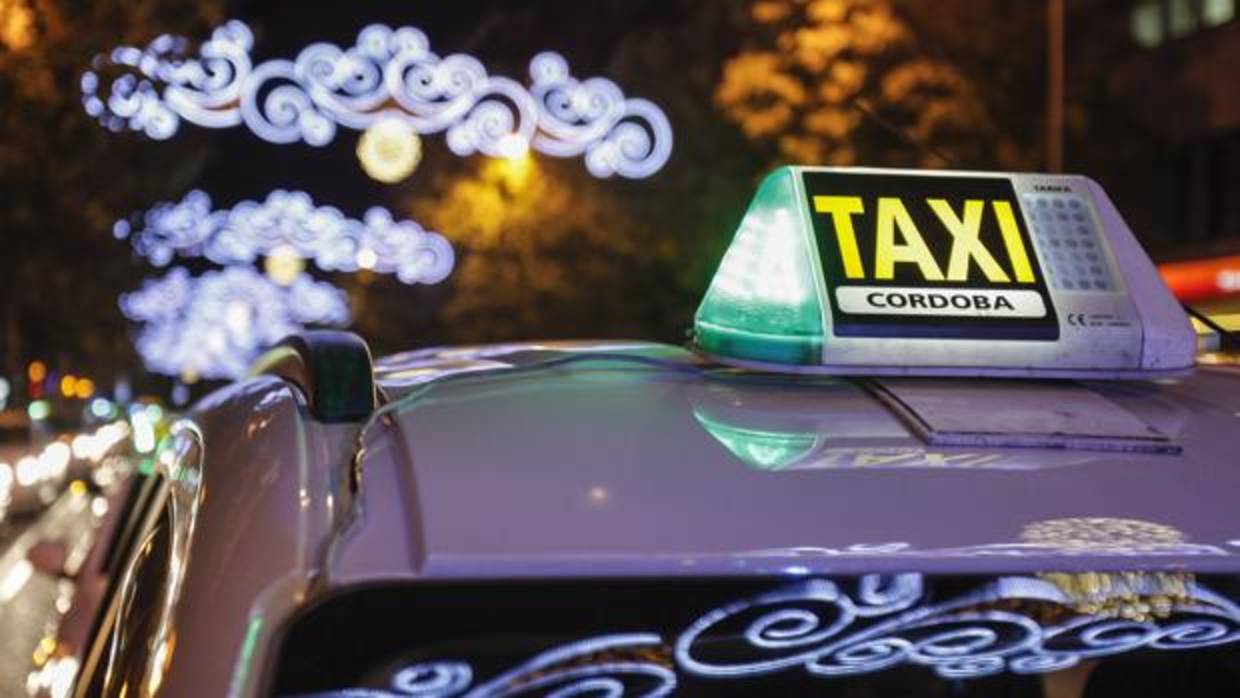 Un taxi circula por las calles de Córdoba bajo el alumbrado navideño