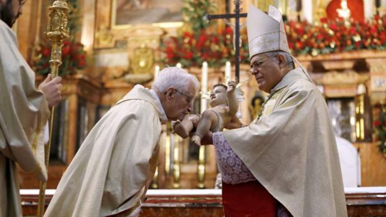 El obispo da a besar la imagen del Niño Jesús al canónigo Manuel Nieto Cumplido