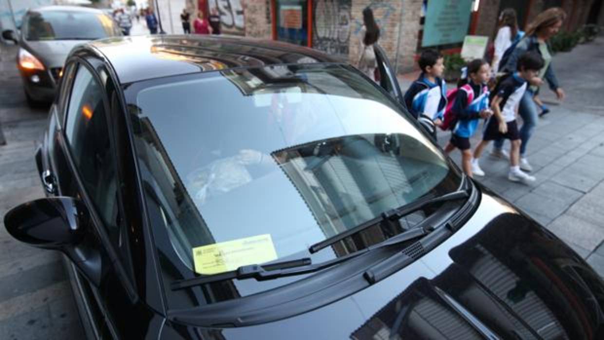 Un coche exhibe el pase que le permite acceder al Centro para llevar a escolares