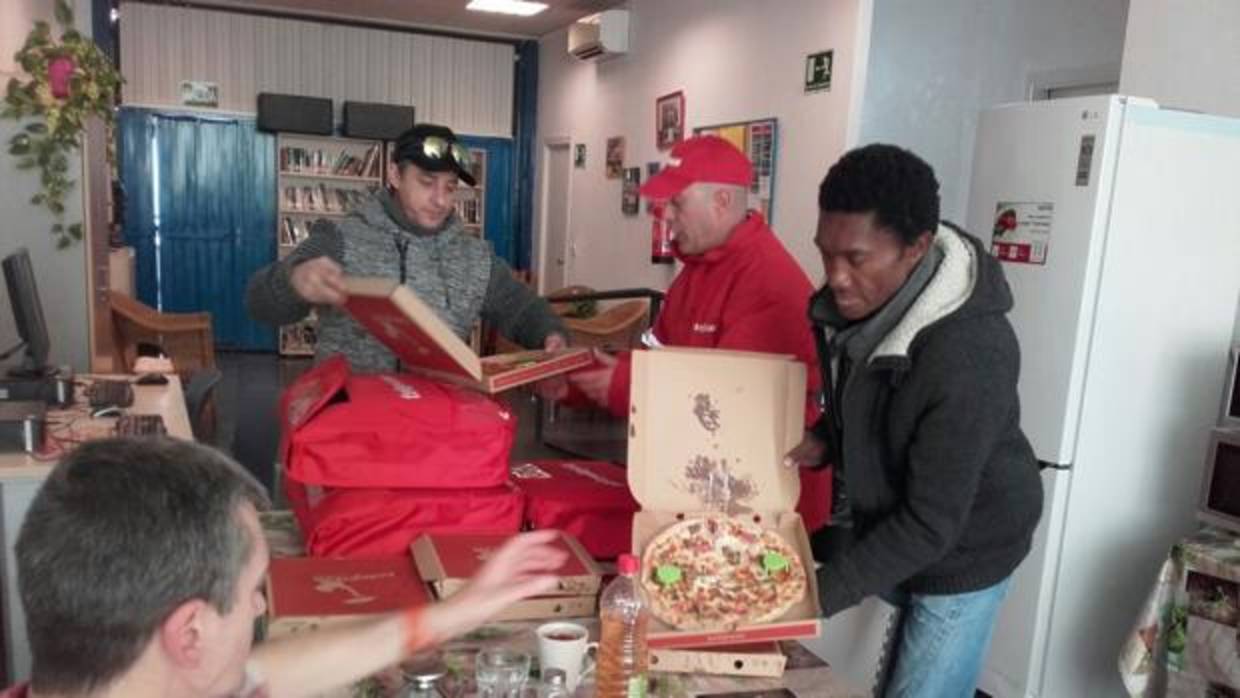 Personas sin hogar recibiendo las primeras pizzas