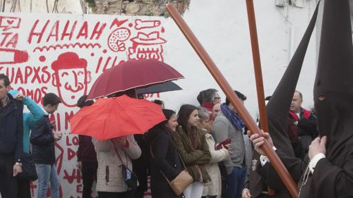 Nazarenos de la Soledad ante público con paraguas