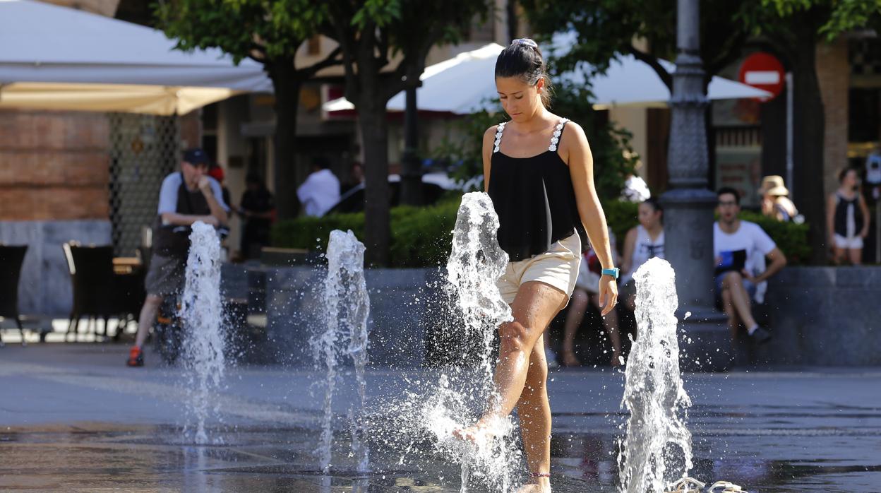 Una joevn se refresca en la Plaza de las Tendillas