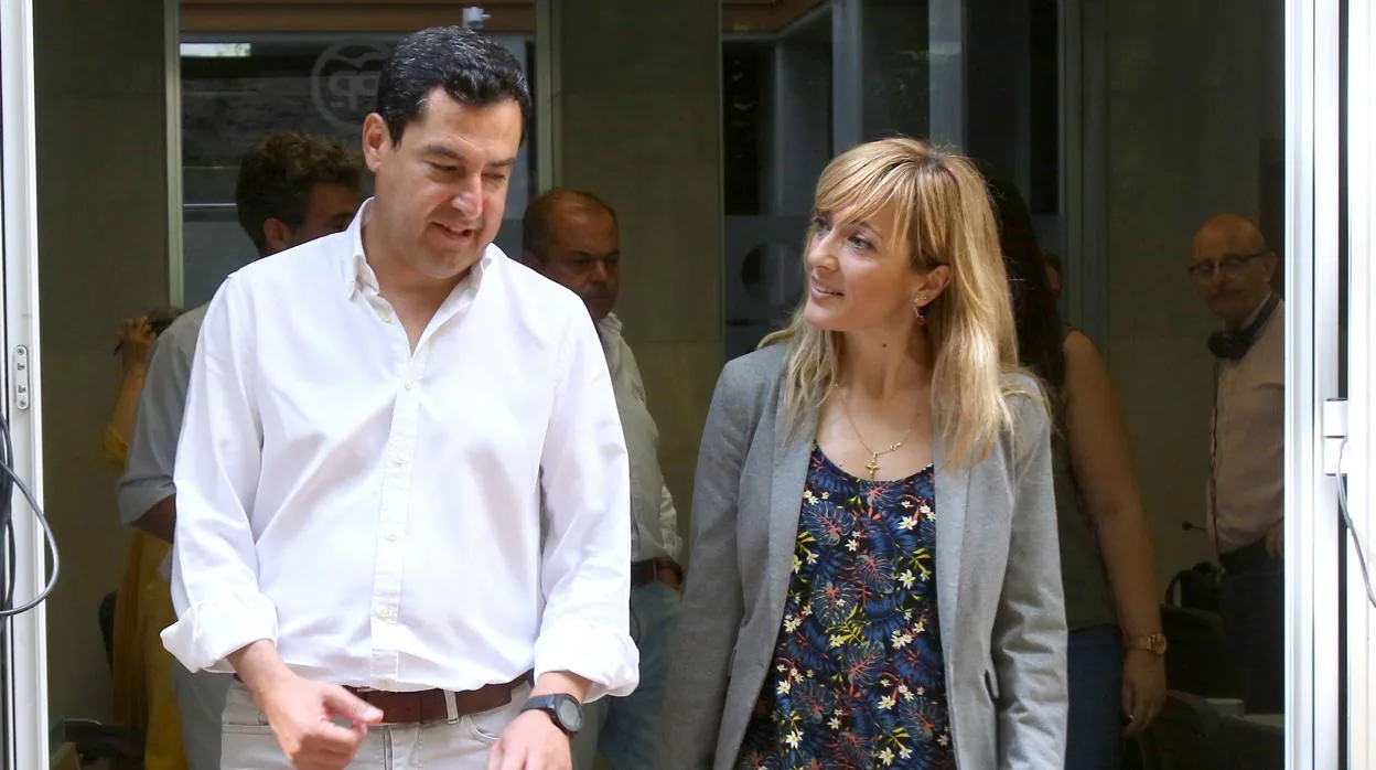 Juanma Moreno, líder del PP andaluz, junto a Carmen Castilla, la secretaria general de UGT este viernes en la sede regional del PP