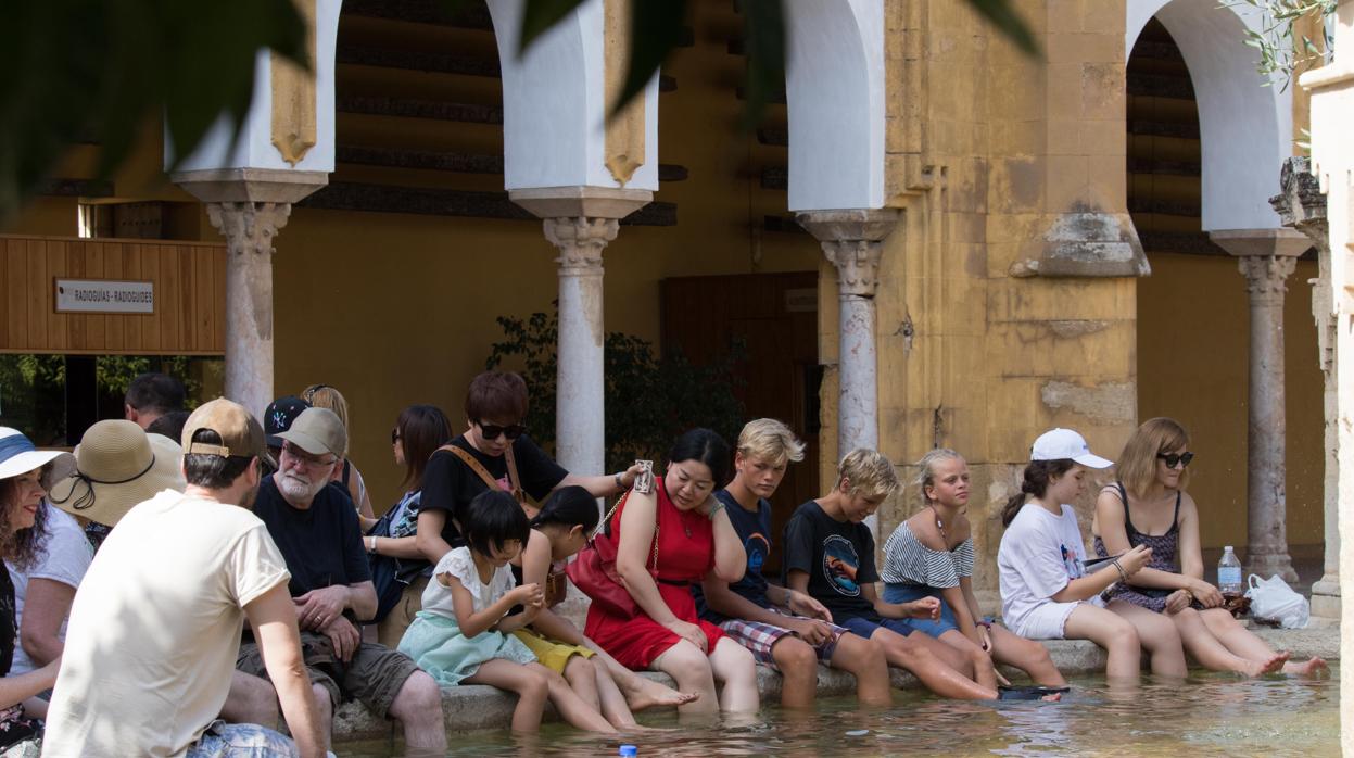 Turistas se refrescan en la fuente del Patio de los Naranjos