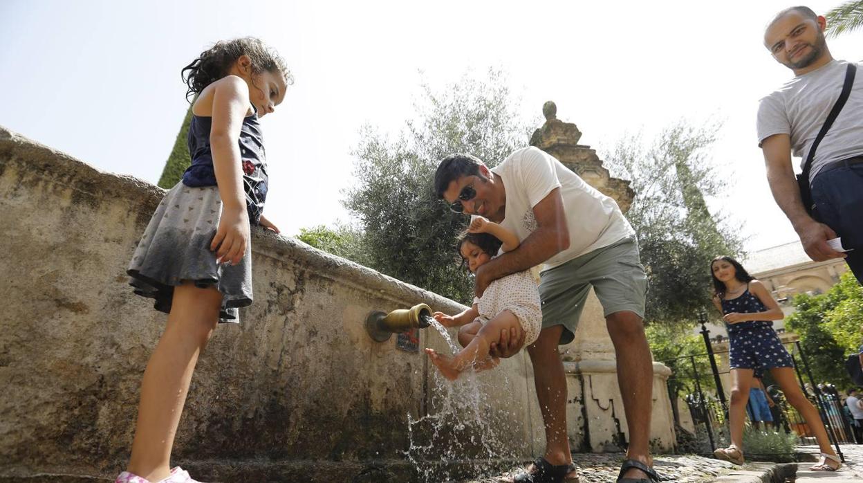 Turistas se refrescan en el Patio de los Naranjos