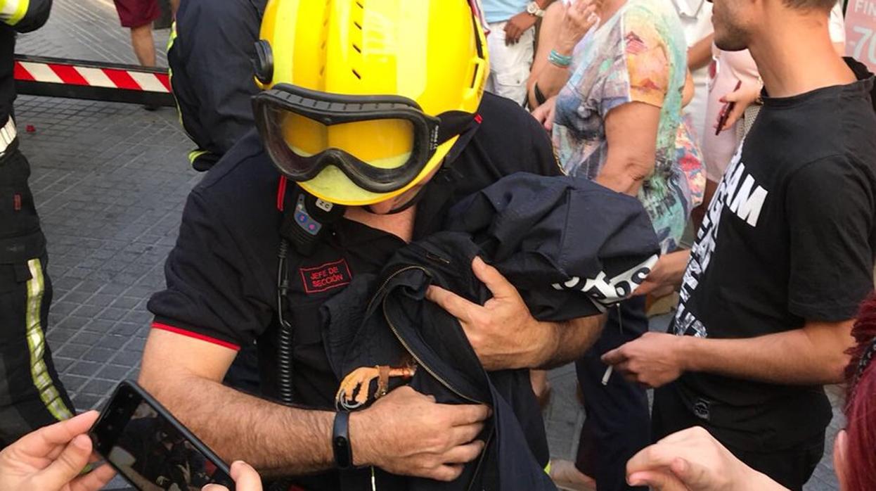 Un bombero con el águila rescatada envuelta en una chaqueta