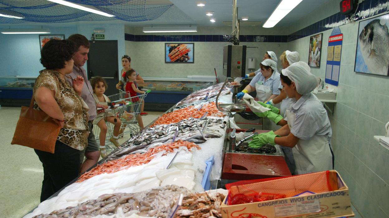 Unos clientes son atendidos en una pescadería