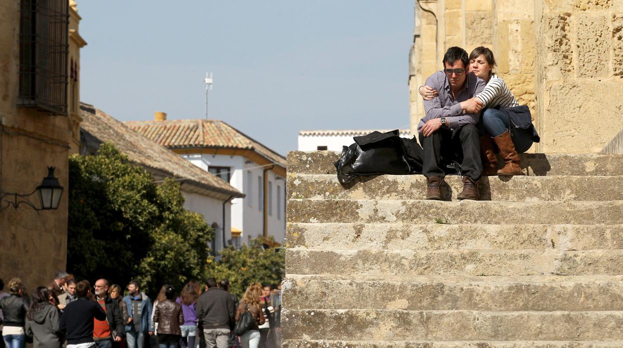 Una pareja de turistas descansa en las escalinatas exteriores de la Mezquita-Catedral