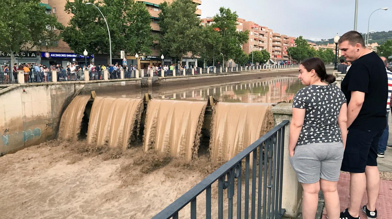 Varias personas observan la crecida del rio Genil, a su paso por Granada