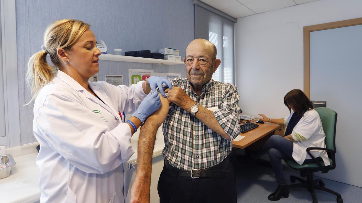 Una enfermera vacuna a un hombre contra la gripe en un centro de salud de Córdoba