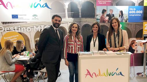 El consejero de Turismo en una feria con un cartel que anuncia la reapertura del Palacio