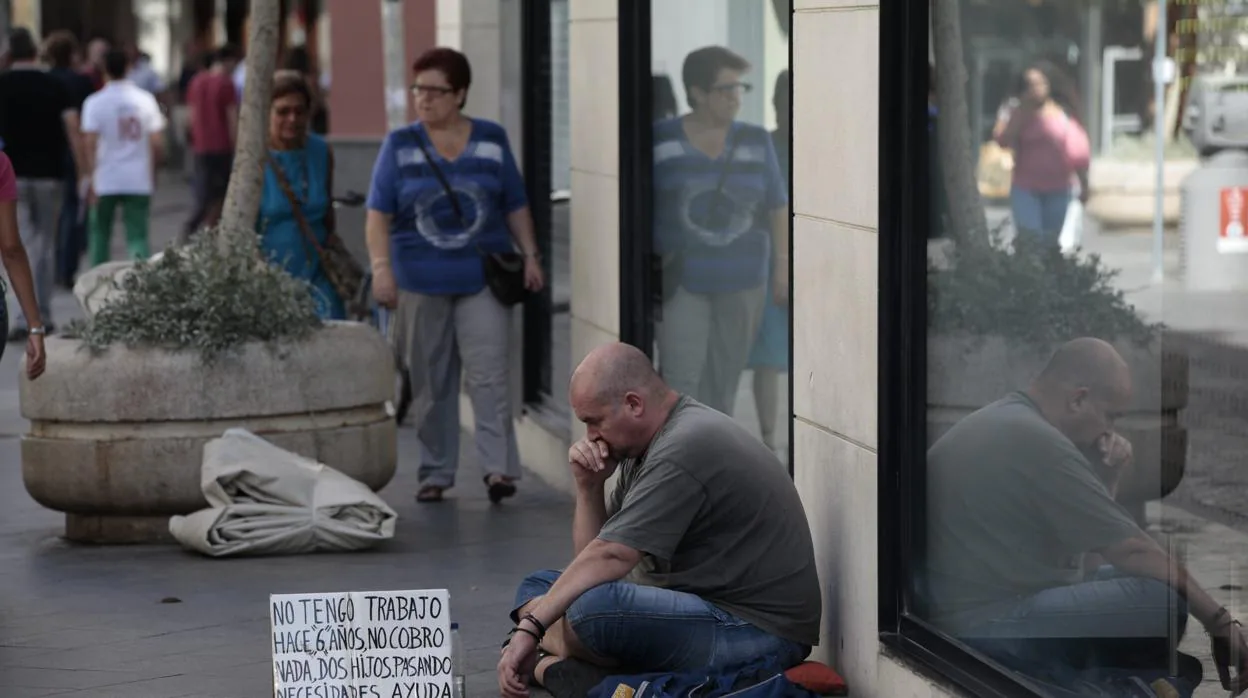 Un hombre pide limosnas en una calle de Andalucía