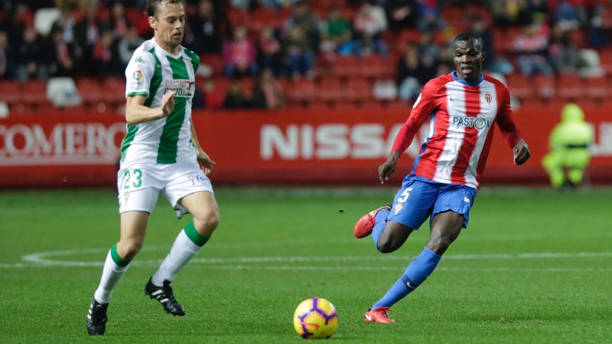 Javi Lara conduce ante Cofie, en el Sporting-Córdoba CF de este viernes en El Molinón