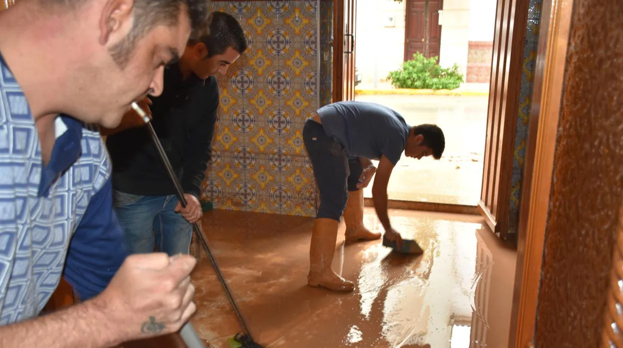 Vecinos achican agua de su casa en Campillos el pasado domingo