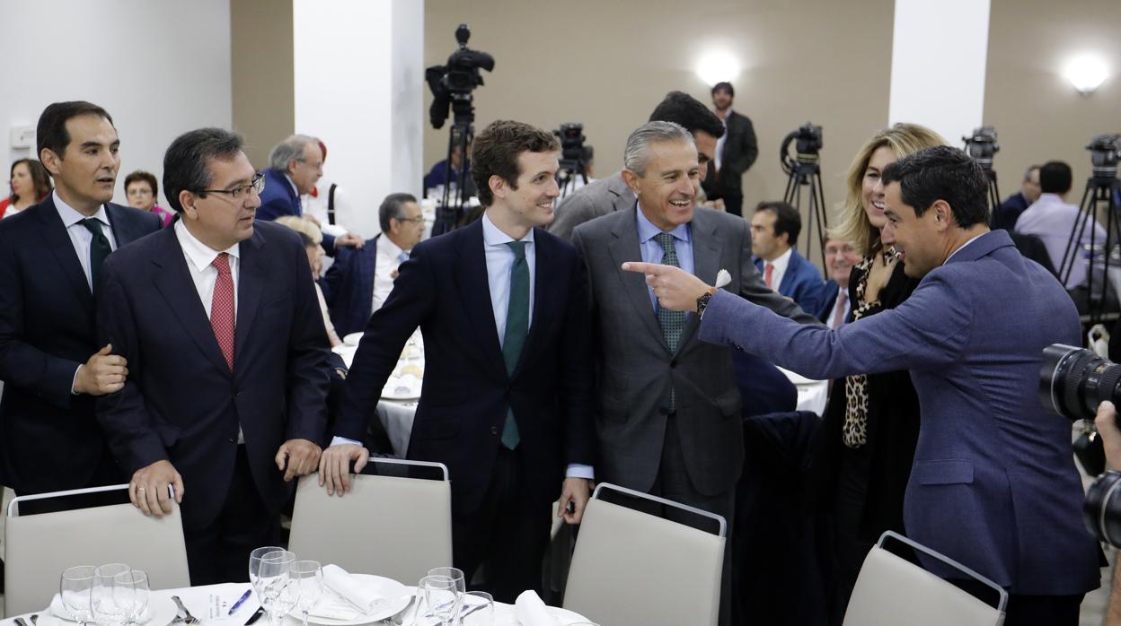El presidente del PP en España mira a Juanma Moreno al inicio del acto en el Hotel NH Guadalquivir
