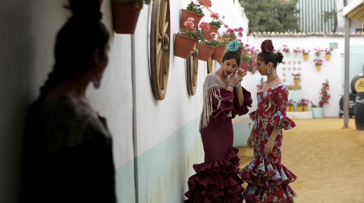 Tres jóvenes vestidas de gitana en una caseta de la Feria de Córdoba