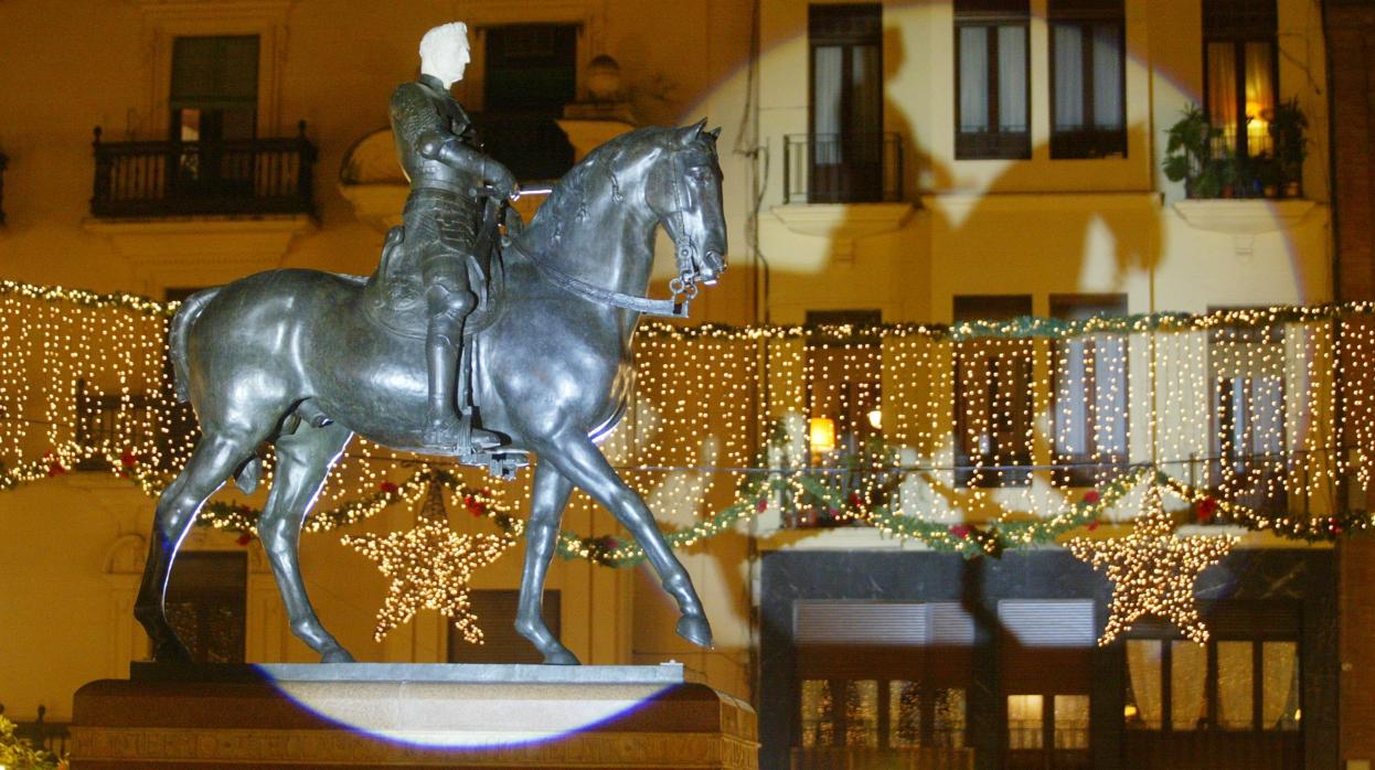 Imagen de la estatua del Gran Capitán con la iluminación navideña al fondo