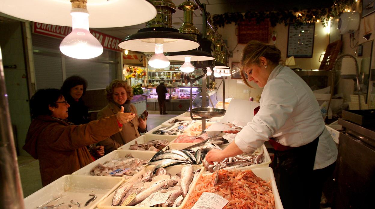 Clientes compran en una pescadería del mercado de la Plaza de España.