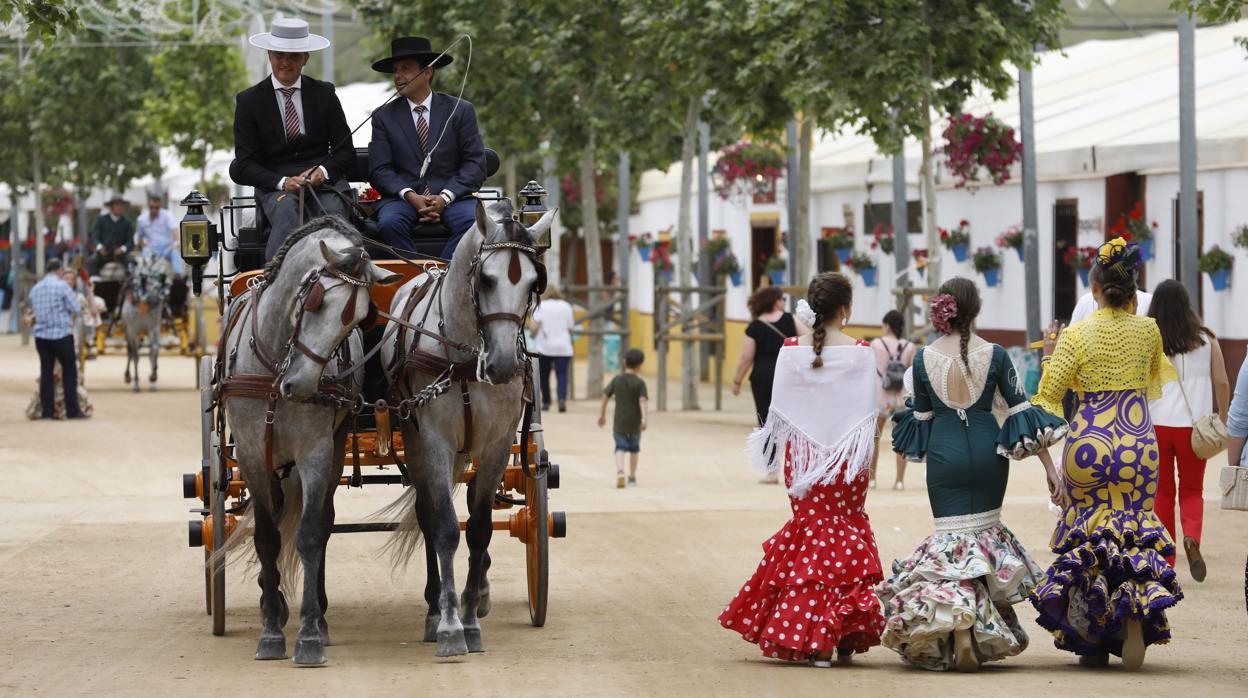 Coches de caballos y jóvenes vestidas de flamenca en la Feria de Nuestra Señora de la Salud de Córdoba