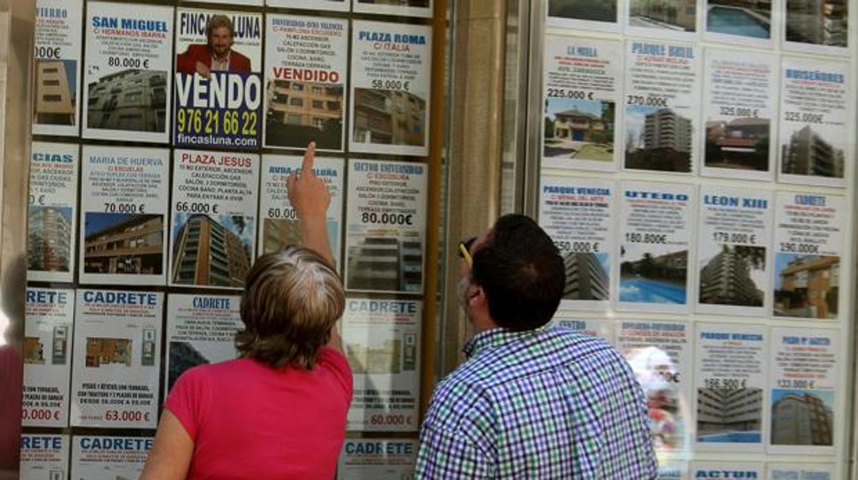 Una pareja viendo viviendas en una inmobiliaria