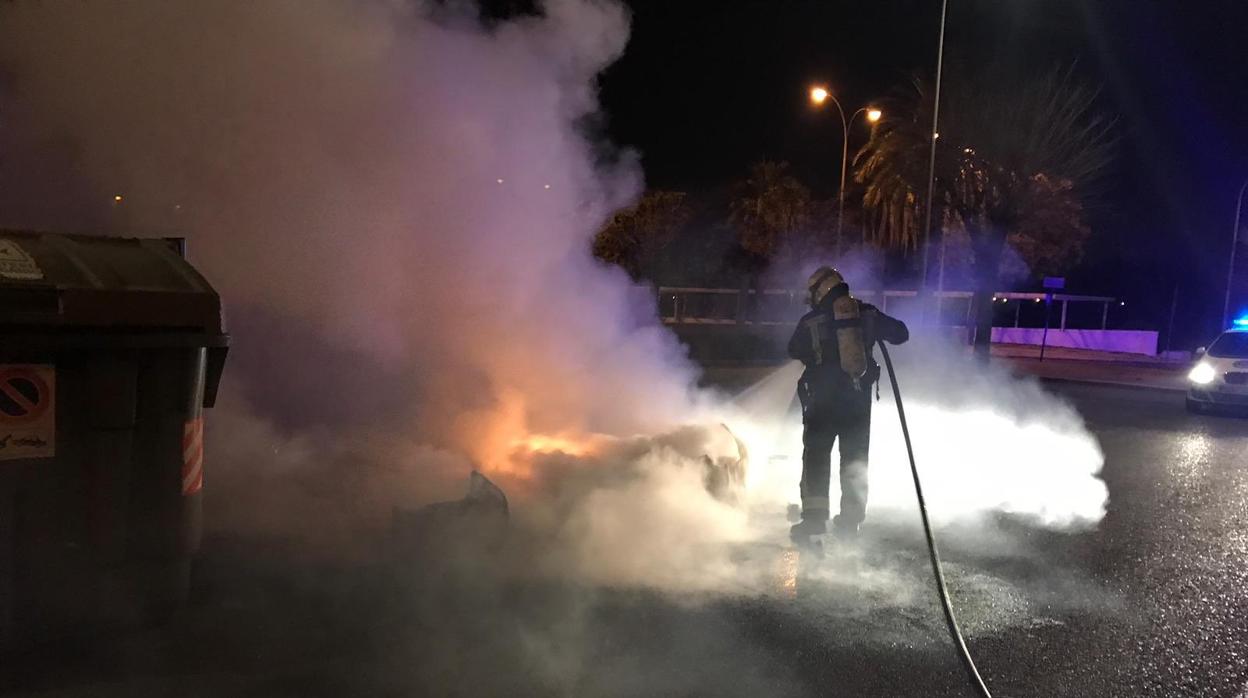 Un bombero sofoca el incendio de un contenedor esta madrugada