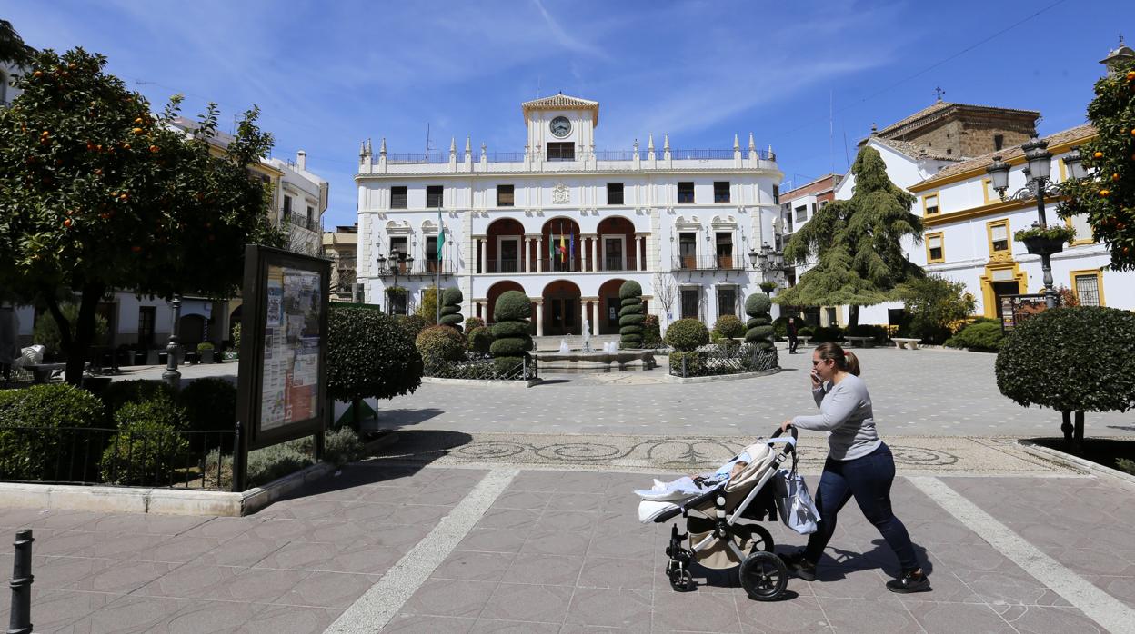 Una mujer pasa delante del Ayuntamiento de Priego de Córdoba