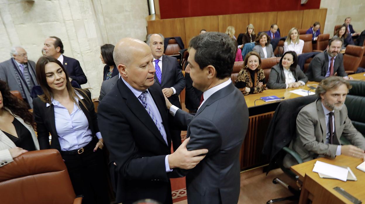 Juanma Moreno charla con Javier Imbroda, consejero de Educación y Deporte, en el Parlamento