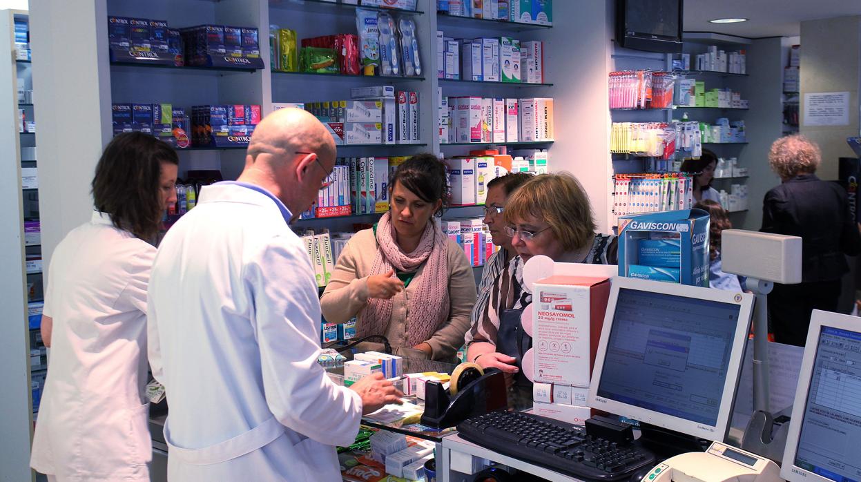 Farmacéuticos atienden a clientes en una farmacia