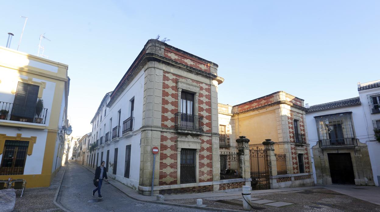 Un joven pasa junto a la Casa de los Burogs, situada frente a la plaza del Museo Arqueológico